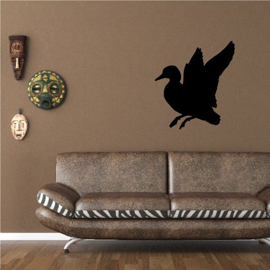 Black duck wall decal silhouette on wall above sofa.