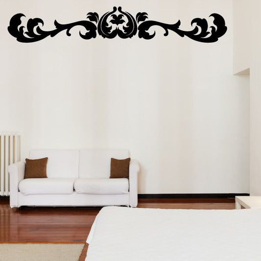 Ornate black damask wall decal with scrollwork border above sofa
