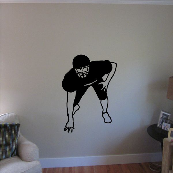 Football player wall vinyl decal, black crouching silhouette with football