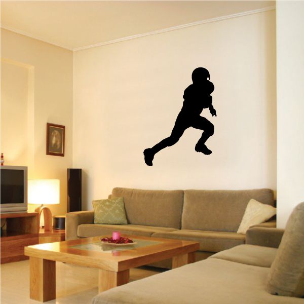 Football wall decal of black soccer player kicking ball silhouette