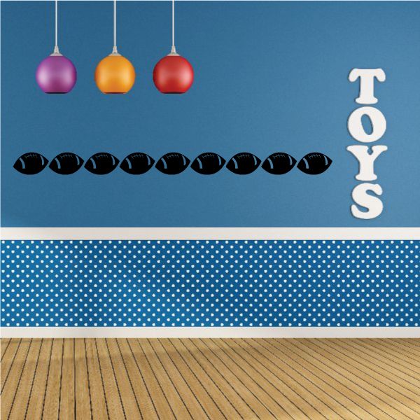 Football wall decal with row of black footballs and white TOYS lettering