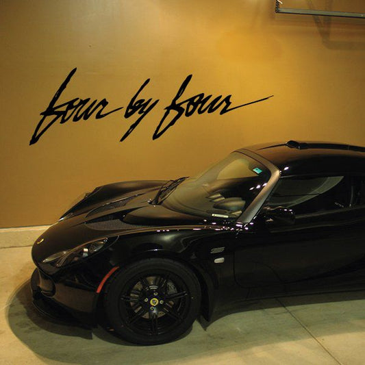 Cursive black text decal reading “four by four” on a light background