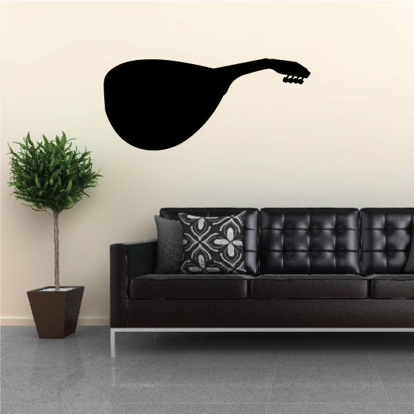 Couch with a black guitar decal on the wall behind it