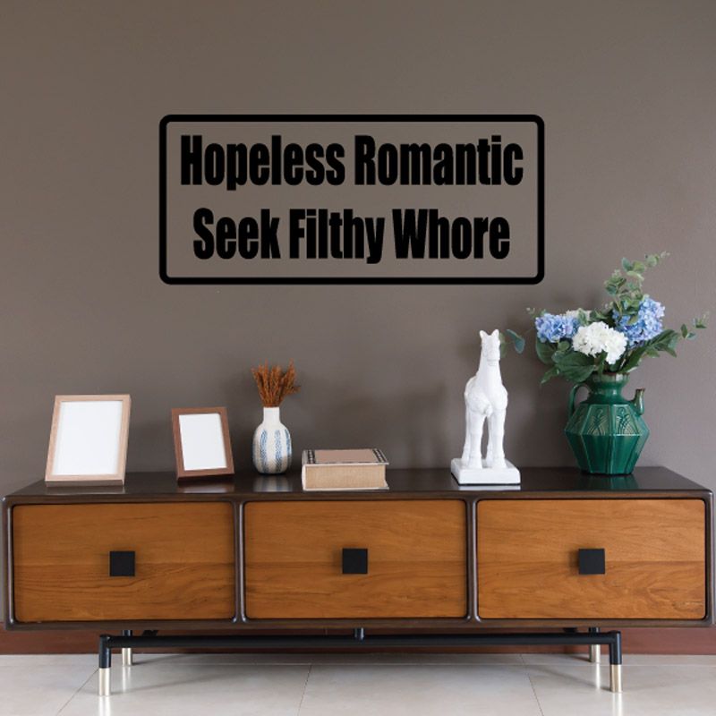 Rectangular black-bordered wall decal with bold text 'Hopeless Romantic' and 'Seek Filthy Whore'.
