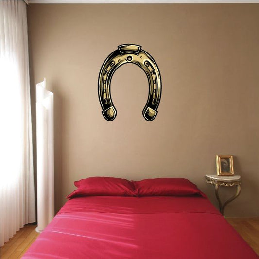 Gold horseshoe wall sticker with black outline and small star studs