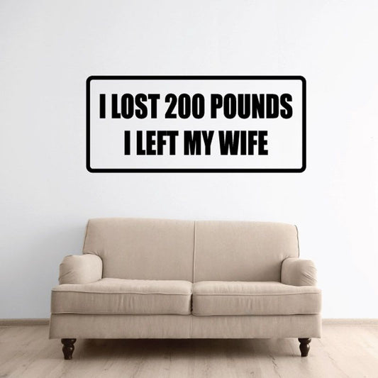 Rectangular wall decal with bold black text: I LOST 200 POUNDS I LEFT MY WIFE