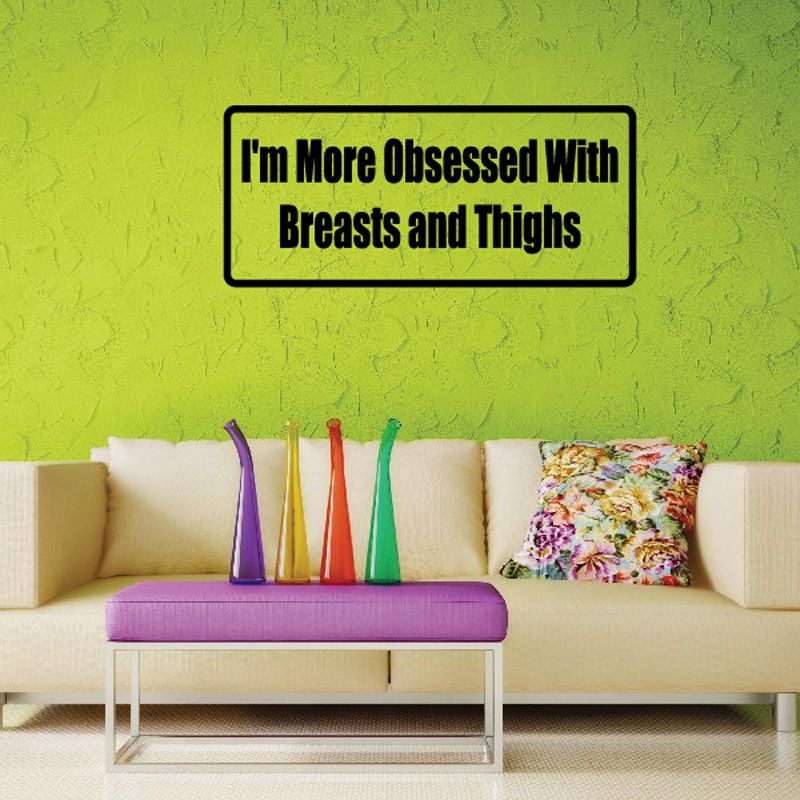 Rectangular wall decal with black border and bold text reading “I'm More Obsessed With Breasts and Thighs”