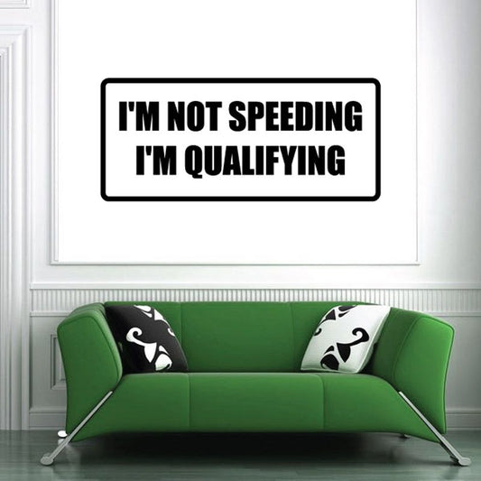 Rectangular decal with black border: "I'm not speeding, I'm qualifying"