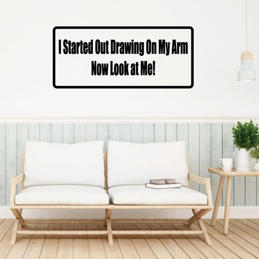 Rectangle wall decal with bold black quote: “Started Out Drawing On My Arm” / “Now Look At Me”