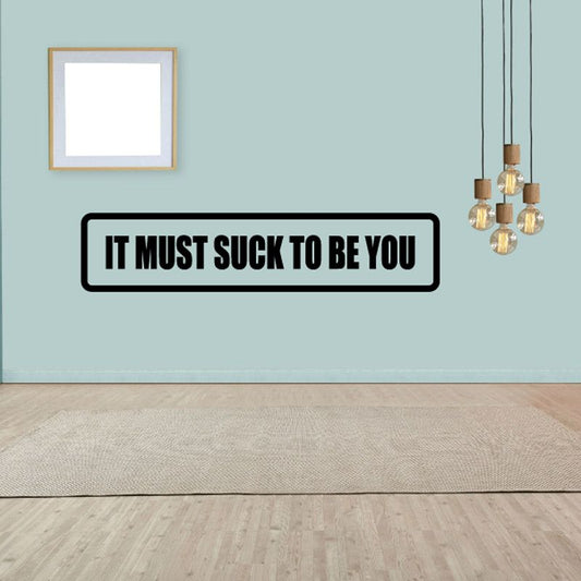 Wall decal with bold black border and white text: 'It must suck to be you'.