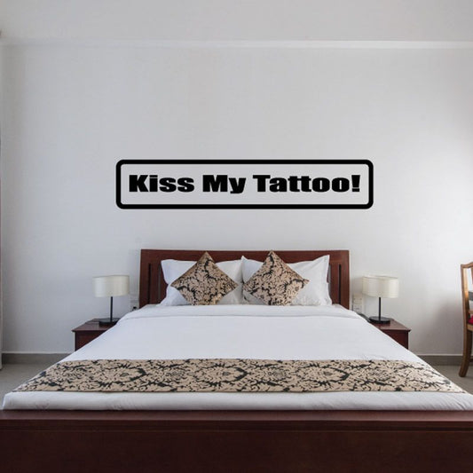 Wall decal with bold black text “Kiss My Tattoo!” in a rounded rectangle