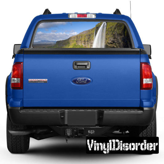 Pickup truck rear window with mountain landscape graphic, waterfall view
