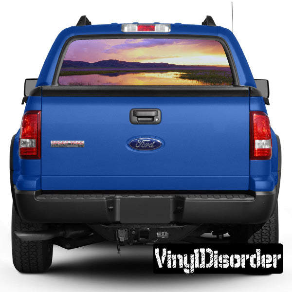 Blue pickup truck rear with landscape graphic in back window