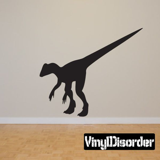 Black dinosaur wall decal with long tail and clawed feet