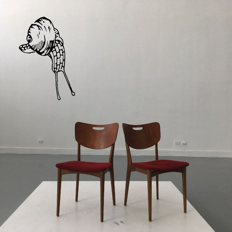 Snail decal with eyes and antenna, looking upward on a wall