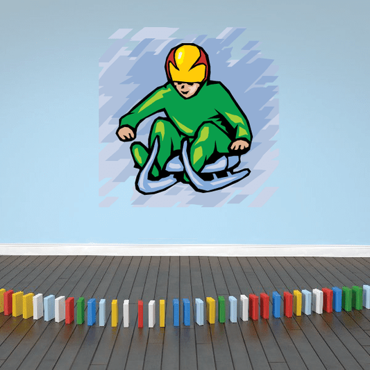 Green sledding child die-cut decal with yellow hood and blue sled