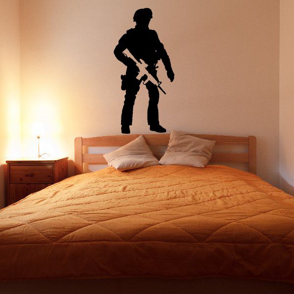 Soldier with rifle wall decal silhouette on a wall above a bed