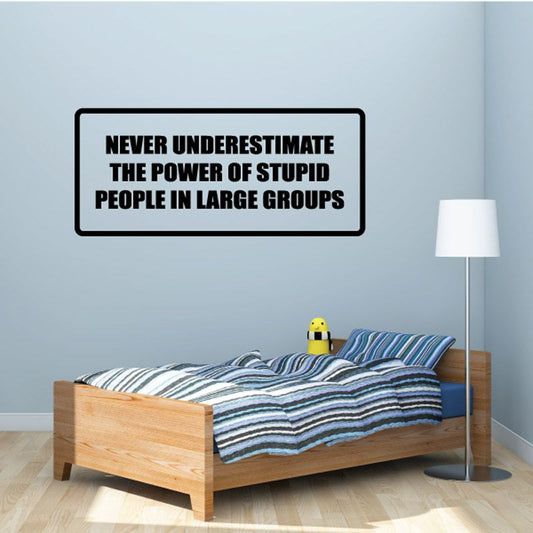Wall decal with black outline and bold white text: “NEVER UNDERESTIMATE THE POWER OF…”
