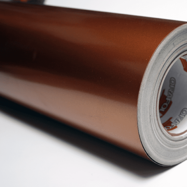 Gloss metallic copper vinyl roll with release liner, adhesive tape backing visible