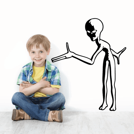 Child enjoying a playful moment with an alien wall decal in the background