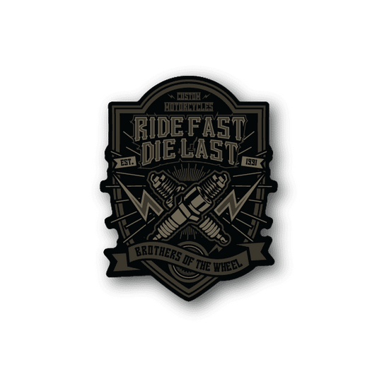 Vinyl sticker, black and gold motorcycle crest: “Ride Fast Die Last”.