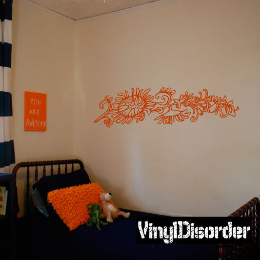 Wall decal with orange ornate floral scroll across a wall