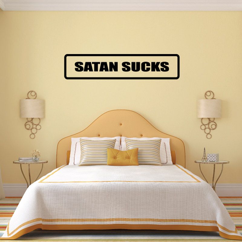 Wall decal with bold black text 'SATAN SUCKS' in a white rounded rectangle