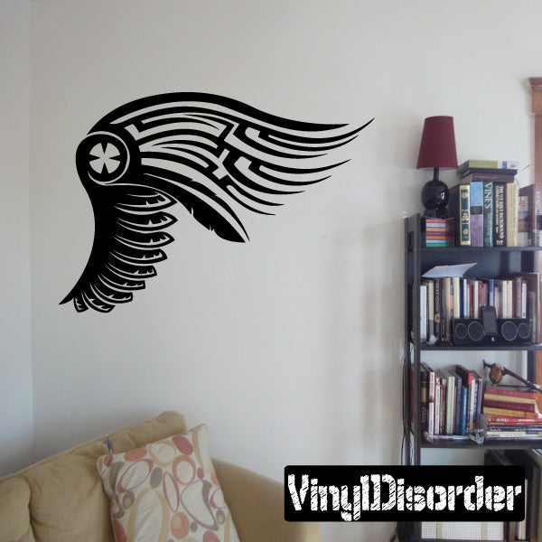 Black tribal wing wall decal with starburst center and striped feather texture.