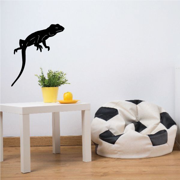 Black sitting lizard wall decal with raised tail and legs