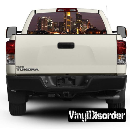 White pickup rear window city skyline graphic decal, tailgate and backup camera visible