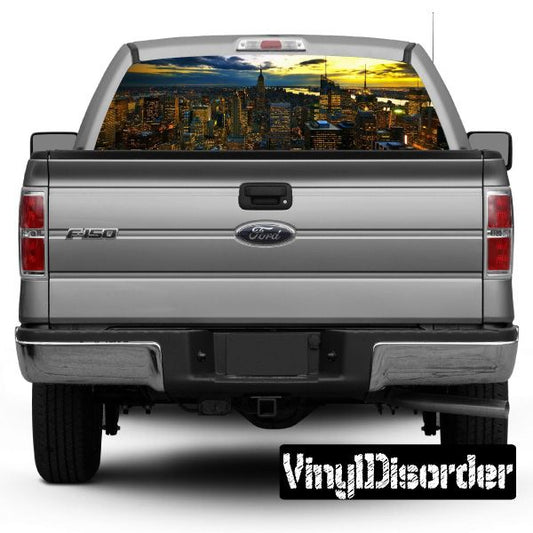 Gray pickup truck rear with city skyline graphic rear window and tail lights.