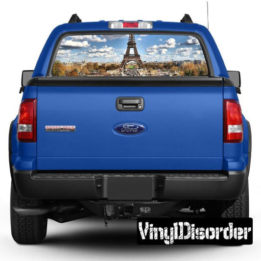 Blue car rear tailgate with rear window skyline graphic, visible lights and exhaust