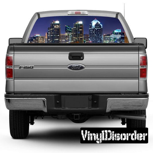 Car rear window skyline graphic with city buildings and night lights on dark window