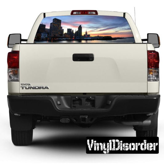 Pickup truck rear window skyline graphic with sunset city view