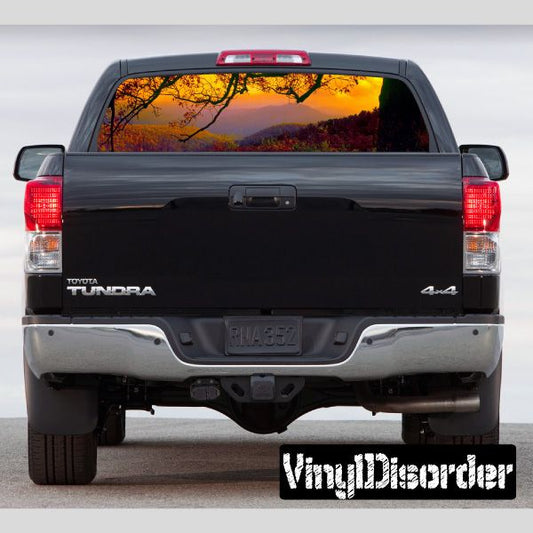 Pickup truck rear window graphic with sunset city scene, black border