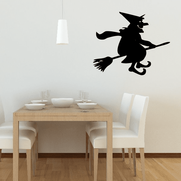 Black witch on broom wall decal, smiling cartoon silhouette.