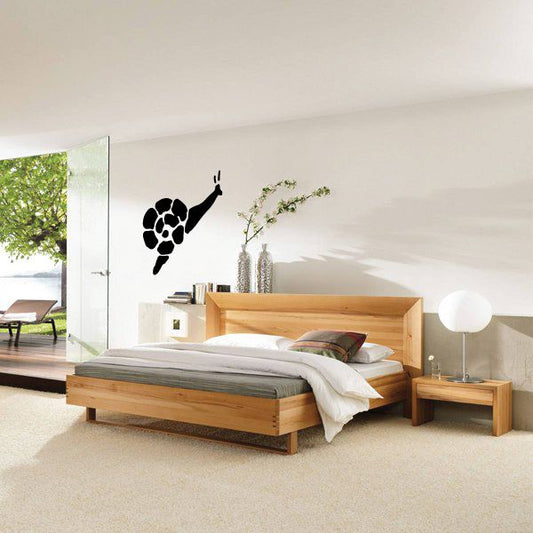 Black snail crawling wall decal with detailed shell and upward antenna