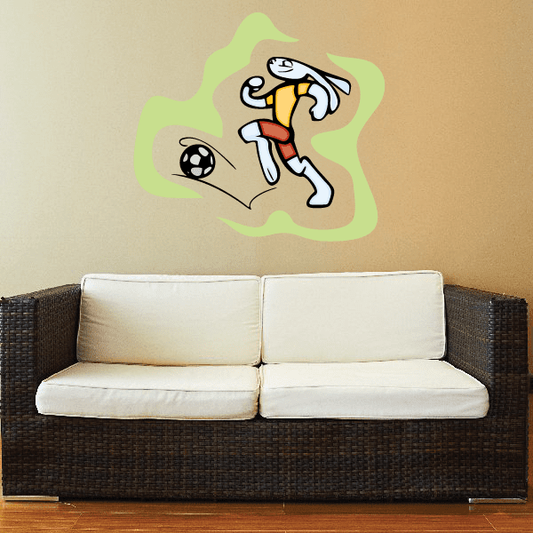 Soccer wall decal: cartoon player kicking black-and-white soccer ball, yellow jersey, red shorts.