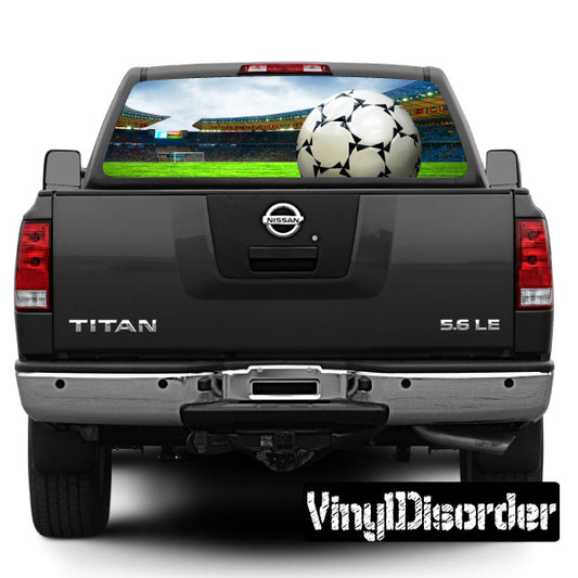 Soccer rear window graphic with large ball on pickup tailgate, Nissan badge visible