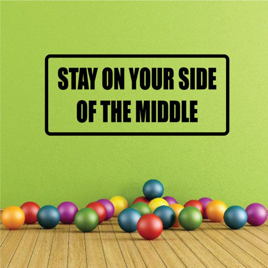 Black-bordered wall decal: 'STAY ON YOUR SIDE OF THE MIDDLE'.