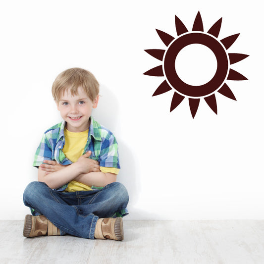 Little boy in a room with a playful sun decal on the wall