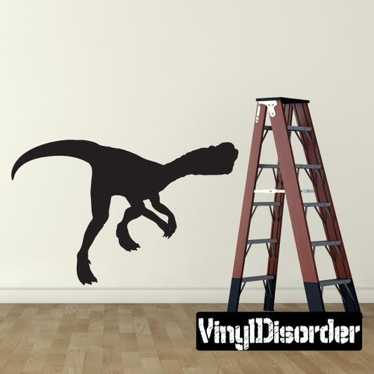 Black walking dinosaur vinyl wall decal with long tail and claws