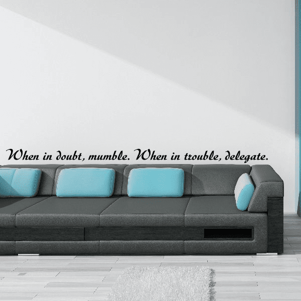 Wall quote decal with cursive text: “When in doubt, mumble. When in trouble, delegate.”