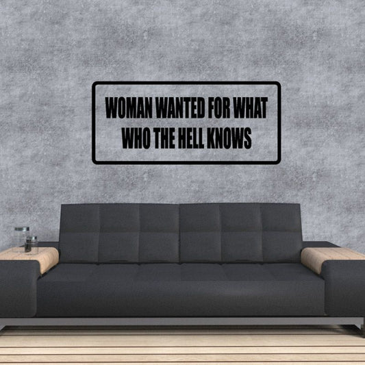 Wall decal with bold black border and white text reading “WOMAN WANTED FOR WHAT”