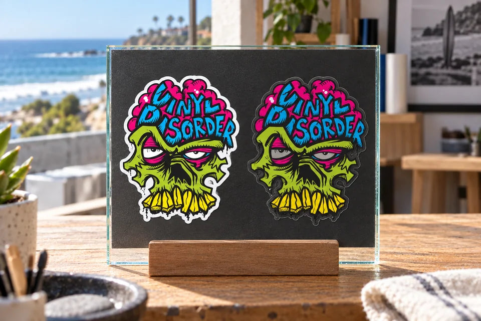 The same skull artwork on opaque white stock at left and clear film over a dark surface at right.