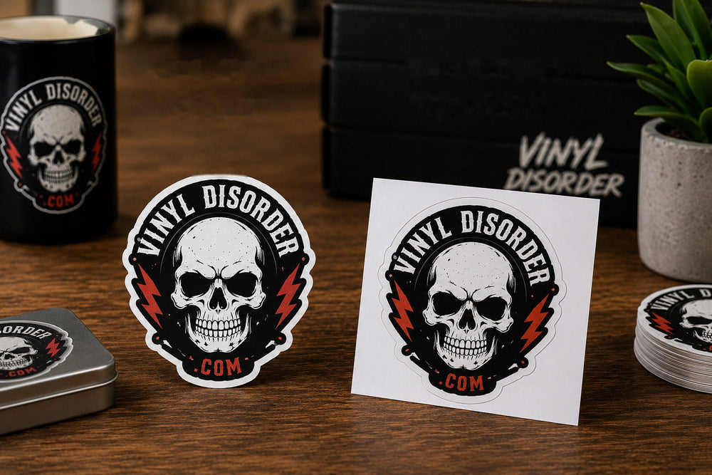 Die cut and kiss cut Vinyl Disorder skull sticker samples side by side on a wood tabletop