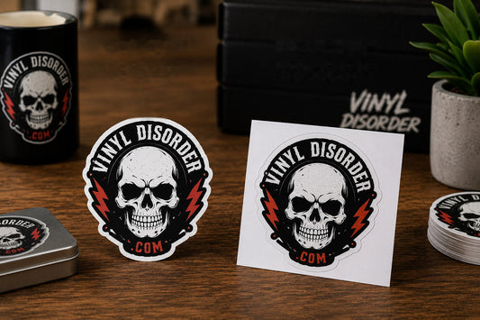 Die cut and kiss cut Vinyl Disorder skull sticker samples side by side on a wood tabletop