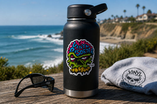 Colorful Vinyl Disorder sticker on an insulated bottle at a sunny coastal overlook