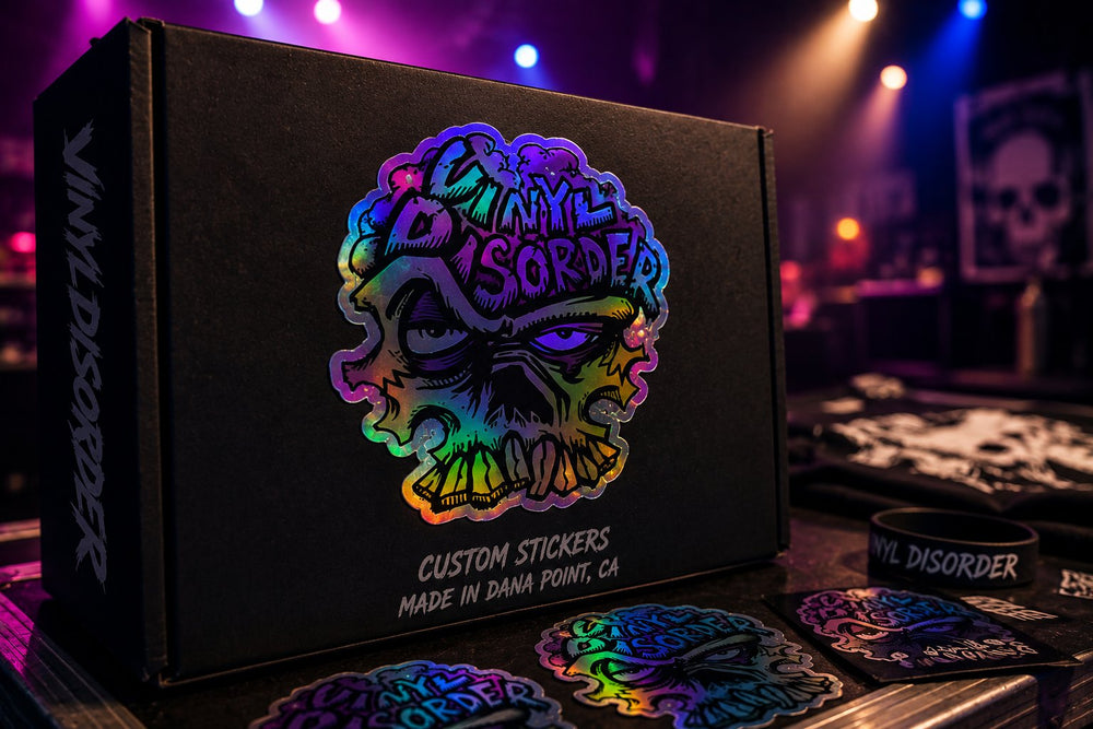 Oil slick Vinyl Disorder sticker on black merch packaging under colorful stage lighting