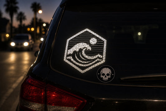 Reflective wave icon sticker glowing on the rear window of a dark SUV at dusk